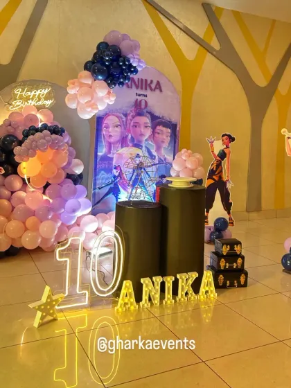 A dynamic shot of the 'Huntrix' party decor, highlighting the layered backdrops and balloon arrangements.
