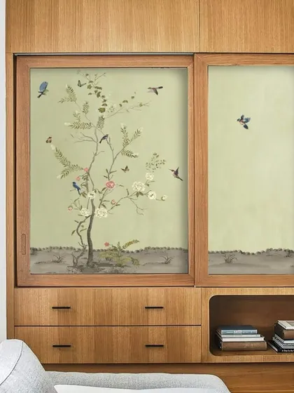 Here, I used a beautiful Chinoiserie-style wallpaper with birds and blossoms on sliding wardrobe doors. This design adds a calming, artistic element to the room while cleverly concealing storage.