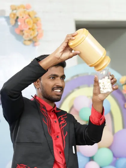 What's a party without some magical snacks? Here I am performing a production trick, making popcorn appear from an empty container. It's a visual and surprising illusion that always delights the audience.