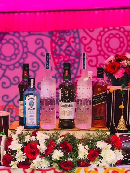 Let's bring the vibrant energy of Punjab to your celebration with a 'Funjabi' themed bar. This setup features premium spirits displayed amidst traditional dhols and bright floral arrangements, perfect for a high-energy Haldi or Mehendi ceremony.