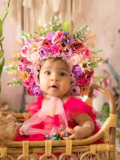 An inquisitive look from the baby during her floral half-birthday session, showing her personality.