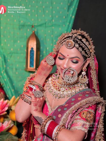 This is a classic Rajasthani bridal look, characterized by the elaborate matha patti, large nose ring (nath), and vibrant lehenga.