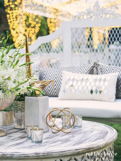 A detail shot of the decor, where modern geometric sculptures in gold and marble sit beside classic white floral arrangements. This mix of contemporary and timeless elements is a signature of our design style.