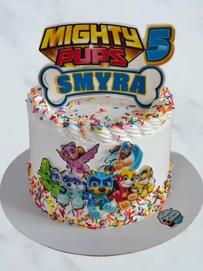 A simple and sweet Mighty Pups cake from the Paw Patrol series. This whipped cream cake is covered in colorful sprinkles and features the team of heroic pups.
