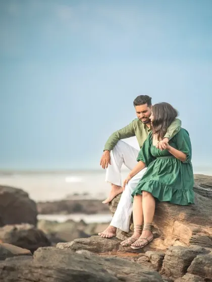 A quiet, intimate moment on the rocks during a pre-wedding shoot. The beautiful coastal scenery provides a stunning backdrop for this romantic portrait.