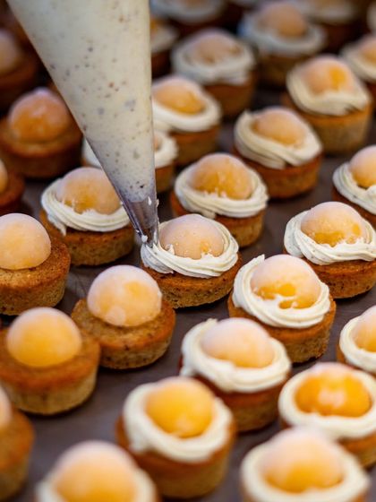 A duplicate of image 44, showing the repetitive, meditative process of preparing desserts for a large event, ensuring each one is identical and perfect.