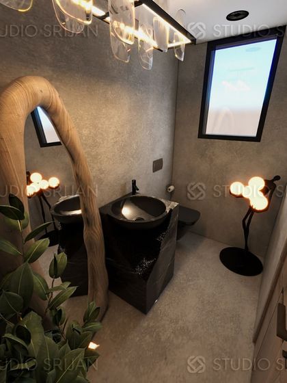 A luxurious powder room in Harsh Vihar, designed with a rustic-modern aesthetic. It features a unique, live-edge wood mirror, a freestanding black stone sink, and artistic, sculptural light fixtures.