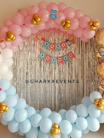 A classic baby shower balloon ring. The frame is decorated with pink and blue balloons, a "Baby Shower" banner, and foil balloons of a baby boy and girl.