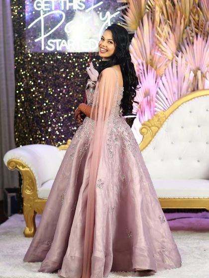 A happy client looking fabulous in our lilac party gown. The attached cape and silver embroidery make it a comfortable yet glamorous choice for dancing the night away at a reception.