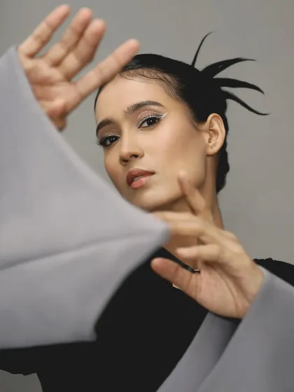 A beautiful pose that frames the face and highlights the clean, sharp line of the white eyeliner.
