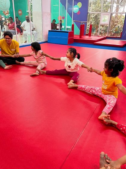 Instructors and kids join hands for a group stretch. This activity promotes flexibility while reinforcing the importance of teamwork and helping one another.