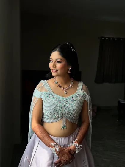 A candid moment of happiness. Her makeup is designed to look natural and fresh, perfect for a daytime Haldi event.