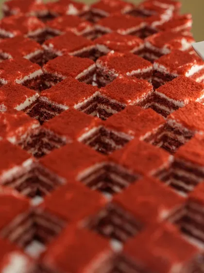 A sea of vibrant red velvet pastry squares, each perfectly layered and dusted. A classic dessert presented with geometric precision.