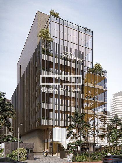 This commercial building, Capital Square, features a volumetric design with a distinctive metal screen covering one section. The design harmonizes modern aesthetics with sustainable elements, creating a visually captivating urban landmark.