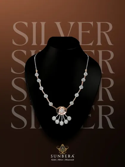 A sophisticated silver necklace with rose gold accents and dangling charms. This piece is a testament to the refined elegance of our silver collection, perfect for creating a striking statement.