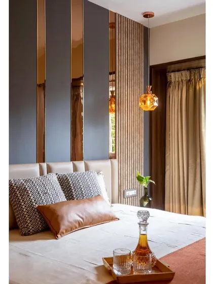 A sneak peek of the master bedroom, highlighting the warm, earthy tones and the interplay of different textures like leather, fabric, and mirrored surfaces.