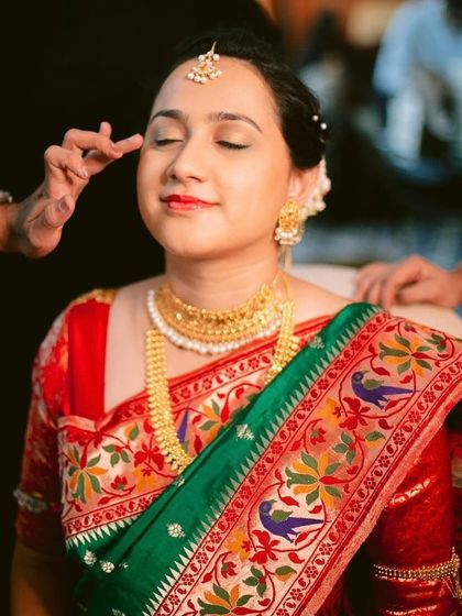 The final touches of makeup being applied to a bride. This shot highlights the precision and care we take in creating a look that is both beautiful in person and on camera.