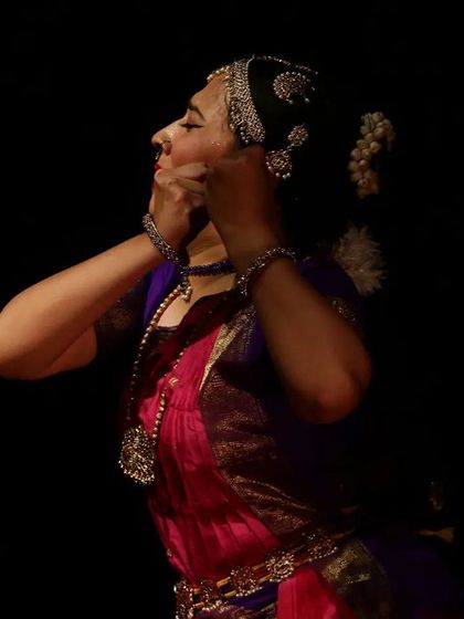 A side profile capturing the intricate hair ornamentation (thalai-saman) and jewelry that completes the dancer's transformation into a character on stage.