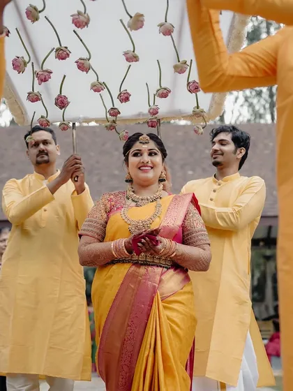 The bride's grand entrance, escorted by her brothers under a custom floral canopy. This is a moment filled with family love and tradition, and we ensure it's as beautiful as she dreamed.