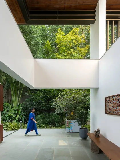 A walkway in a modern home that feels like a stroll through a garden. With open sky-lights and views of the lush exterior on both sides, the architecture is designed to constantly engage with the landscape.