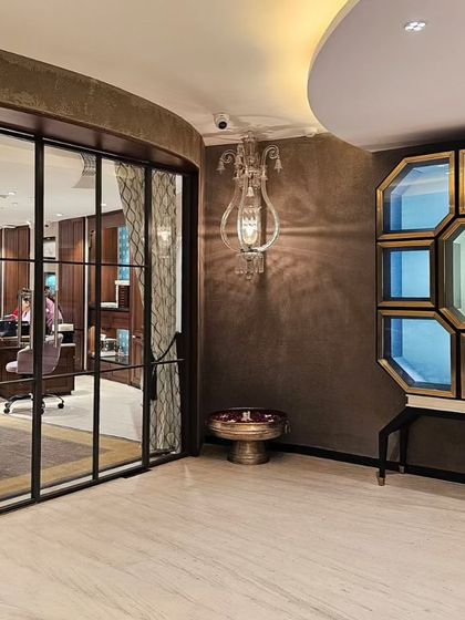 The waiting and reception area at KR Sons is designed to prioritize customer comfort. An octagonal display cabinet and an ornate wall sconce create a luxurious focal point, allowing guests to relax in an inviting atmosphere before their consultation.