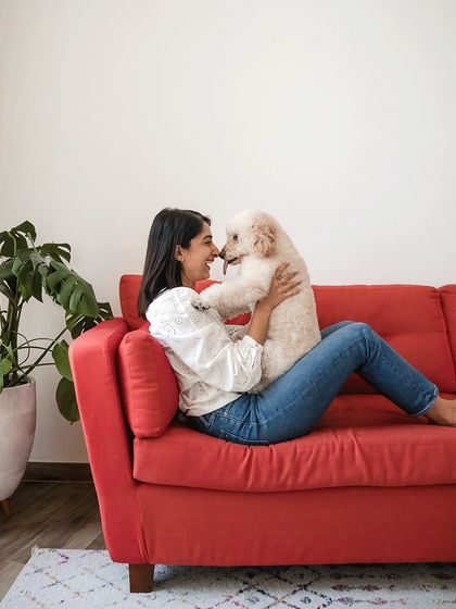 A sweet moment between Dinkan and his mom on their vibrant red sofa. The nose-to-nose connection is a testament to their close bond.