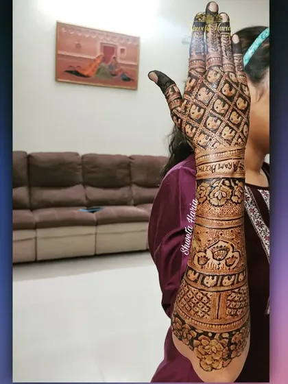 A stunning full-arm back-hand design for a family member. This pattern features traditional motifs like elephants and lotuses, combined with intricate jaali (net) patterns for a truly grand statement.