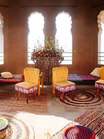 An intimate seating arrangement featuring custom-upholstered chairs and woven stools. Every piece of furniture was chosen to complement the vibrant, handcrafted feel of the Mela theme.