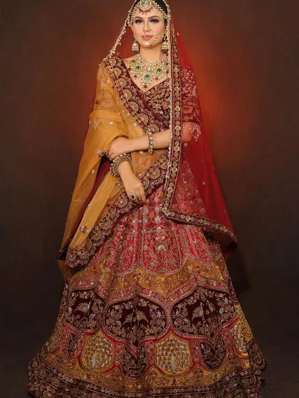 A full view of the bride in her magnificent red and gold lehenga. Our makeup ensures the bride looks stunning from every angle, tying the entire look together.
