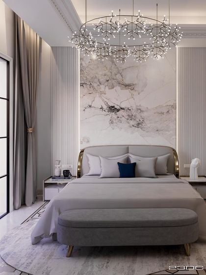 This bedroom is an example of neo-classical design meeting minimal luxury. A stunning modern chandelier hangs above the bed, while a marble feature wall adds a touch of natural elegance. The space is a blend of comfort and high design.
