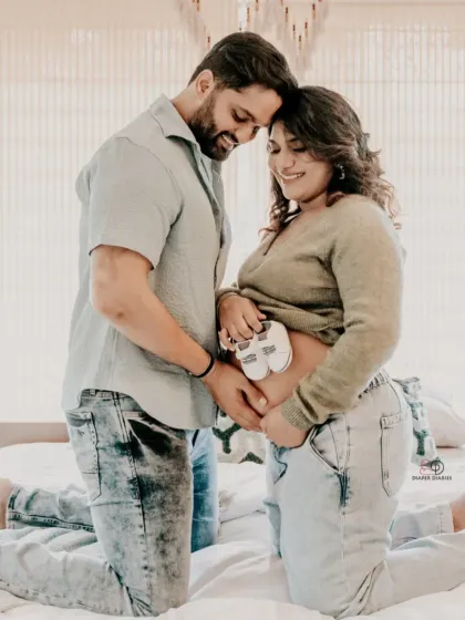 A casual and sweet moment captured in a lifestyle setting. Holding the tiny baby shoes over the bump is a classic way to announce the wonderful news.