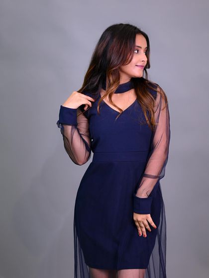 A classic fashion pose that showcases the full silhouette of the dress against a clean studio background.