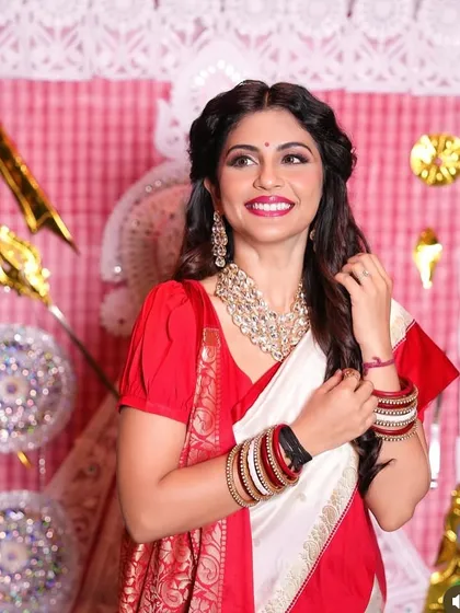 A candid moment showing the beautiful smile of a client in her traditional Bengali attire, with makeup that feels light and comfortable.