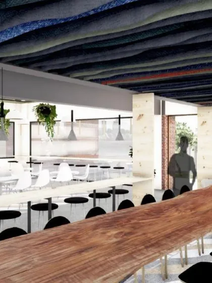 A long communal table made from a single piece of wood serves as a focal point in the JIM canteen. This feature encourages interaction and collaboration among students in a warm, natural setting.
