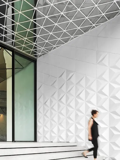 The entrance to the Parinee I Tower, where the three-dimensional triangulated pattern of the GRC wall facade begins. This element creates a seamless transition from the exterior drop-off zone to the immersive lobby inside.