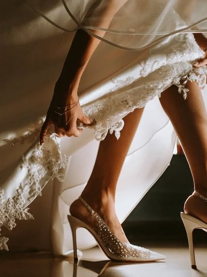 "Of hands and feet, lights and shadows." A detailed, artistic shot focusing on the bride's shoes and the hem of her dress.