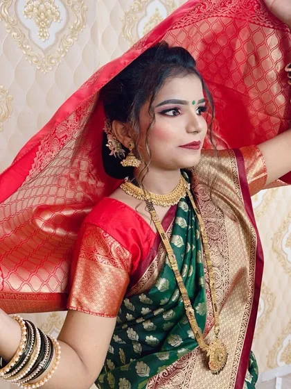 A candid shot of the wedding guest, showing how the makeup and hairstyle look natural and beautiful in motion. The red dupatta adds a lovely contrast to her green saree.