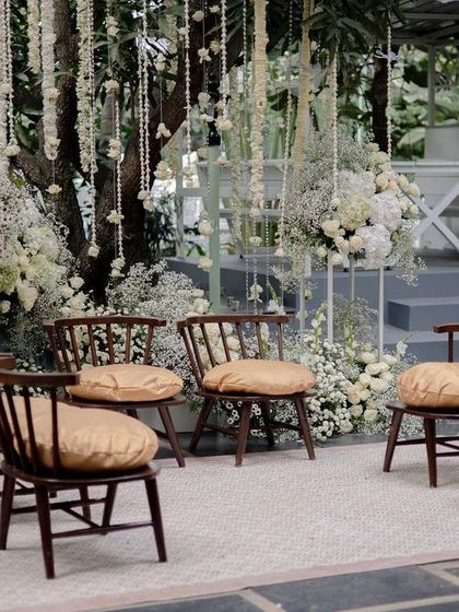 An intimate seating area for the family at an all-white wedding ceremony, surrounded by a cloud of baby's breath and white roses.