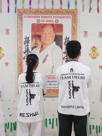 The team stands before the portrait of our founder, Sosai Masutatsu Oyama, showing respect before embarking on their journey.