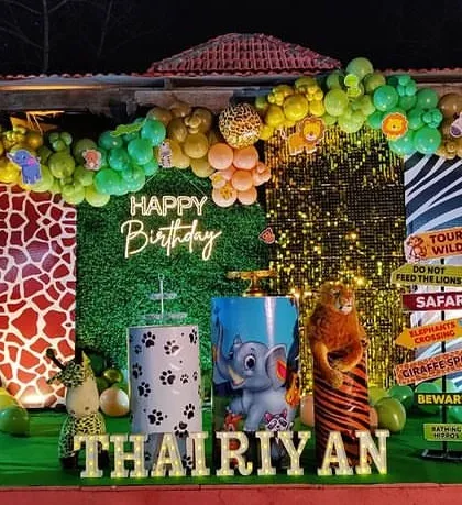 I bring the jungle to your party with this exciting safari-themed birthday decoration. The setup includes a lush green backdrop, animal print panels, an organic balloon arch in jungle colors, and fun props like animal figures and road signs to create an immersive adventure for a first birthday.