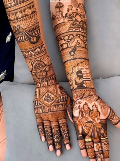 A view of both hands, one with a Shiva-Parvati portrait and the other with a Ganesha symbol.