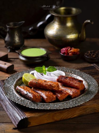 Seekh kebabs served on a traditional silver platter with mint chutney and onions for The Nawaab's.