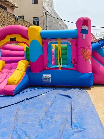 An ice cream and candy-themed bouncy castle. The bright pink and yellow colors, along with popsicle decorations, make it a sweet choice for summer parties.