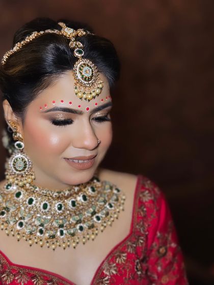 A Bengali-inspired bridal look with the traditional chandan art on the forehead. The makeup is soft and pretty, letting the cultural details shine.