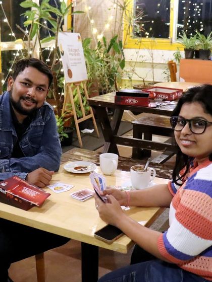 A couple enjoying a quiet game of cards. Our cafe is a great place for a fun and casual date night.