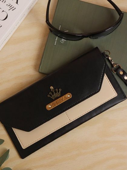 This personalized travel wallet for 'Shreya' is made from dual-tone black and cream vegan leather and is adorned with a crown charm, perfect for the queen in your life.
