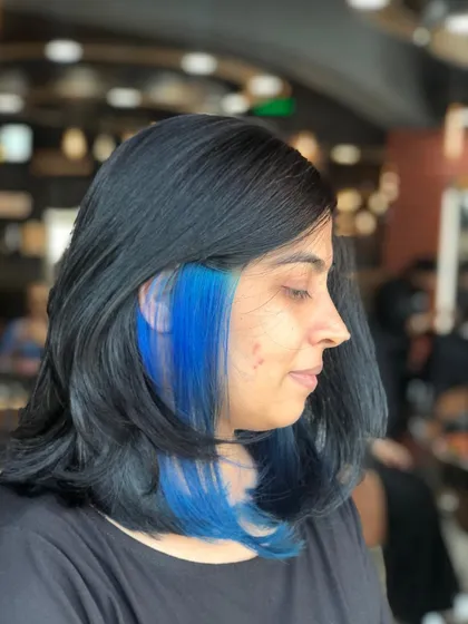 Want to add a little drama? A Peek-a-boo color is the perfect way to do it. This pop of electric blue adds a hidden surprise and a ton of personality, showing up when you move your hair.