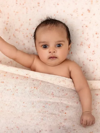A powerful pose from a tiny baby. This simple shot captures a moment of expression and movement, showing the unique personality that shines through even in the first few weeks.