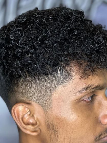 A close-up of a perm with a low fade. You can see the detail in each curl.