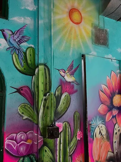 This part of the Mexican-themed mural includes hummingbirds, cacti, and a bright sun, creating a warm and festive vibe.